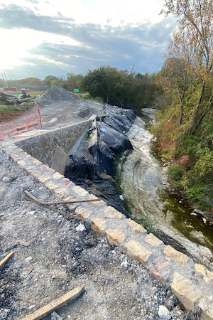 The retaining wall perched atop a steep slope, held in place by deep piers. Photo by Kristi Kerr Leonard.