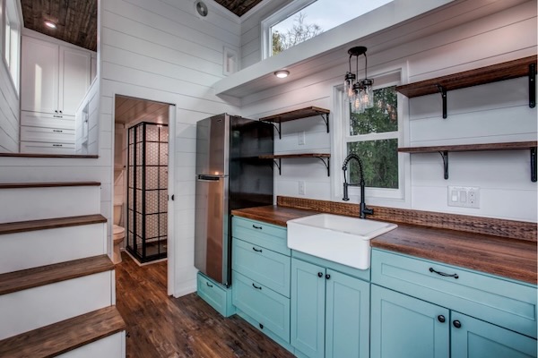 Stairs lead to a stand up loft with three wardrobes in the Magnolia. Courtesy of Indigo River Tiny Homes.