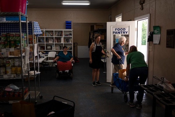 Volunteers and employees at the Leon Community Food Pantry and Clothes Closet in Jewett work together to cart food to a client. Photo by Joe Timmerman, The Texas Tribune.