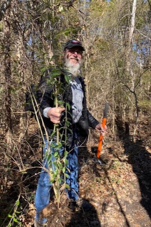 Matthew Saathoff proudly shows off a dug-up privet. Photo by Kate Whidden.