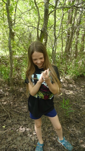 A student holds a ribbon snake