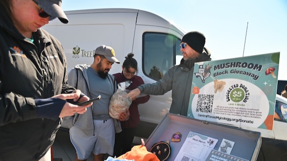 Scott Blackburn of the Central Texas Mycology Society talks to onlookers at the mycology exhibit.