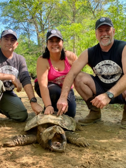 Three people and a large turtle