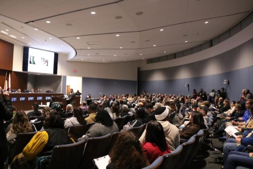 Audience seated in a large conference room, facing a panel of speakers.