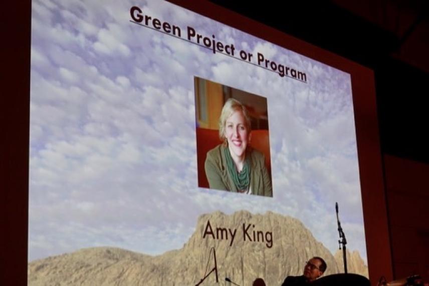 Presentation slide with a woman's photo and mountainous background.