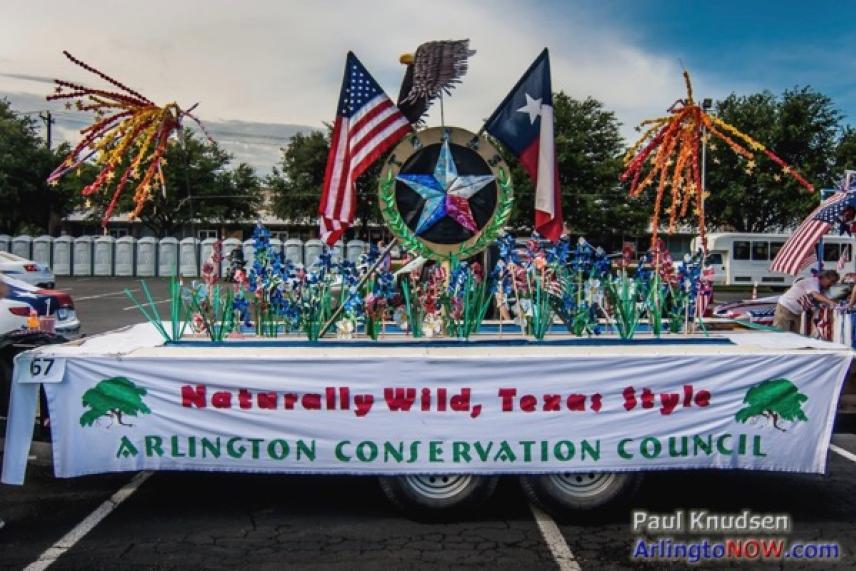 Texas-themed parade float with flags and star, Arlington Conservation Council banner.
