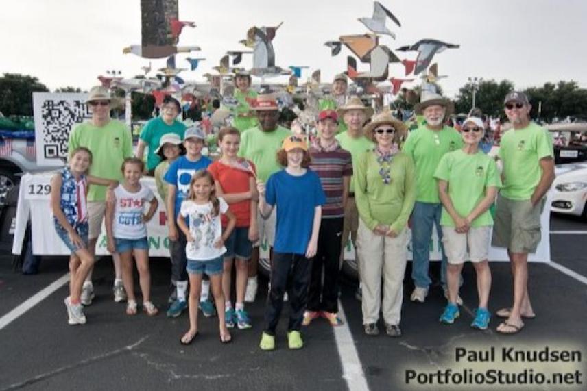 Group of people posing in colorful outfits in a parking lot.
