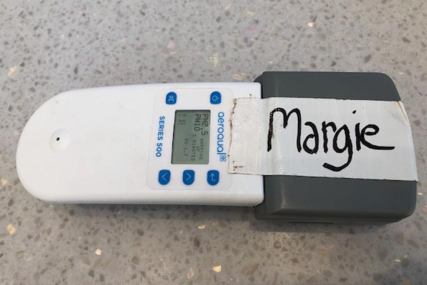 White handheld device with buttons, labeled "Margie" on gray end.