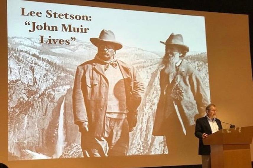 Historical photo projected on screen, speaker at podium.