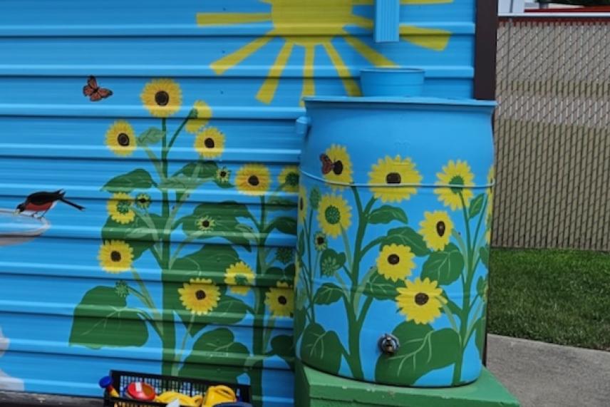 Blue mural with sunflowers, sun, and butterflies.