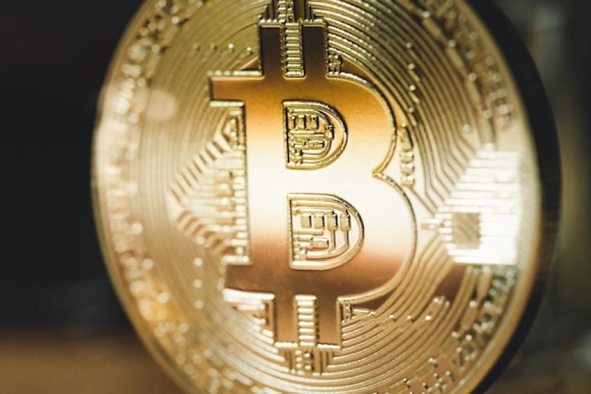 Bitcoin logo on a golden coin, close-up.
