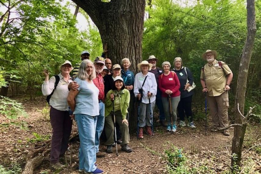 Group of hikers posing together in a lush forest setting.