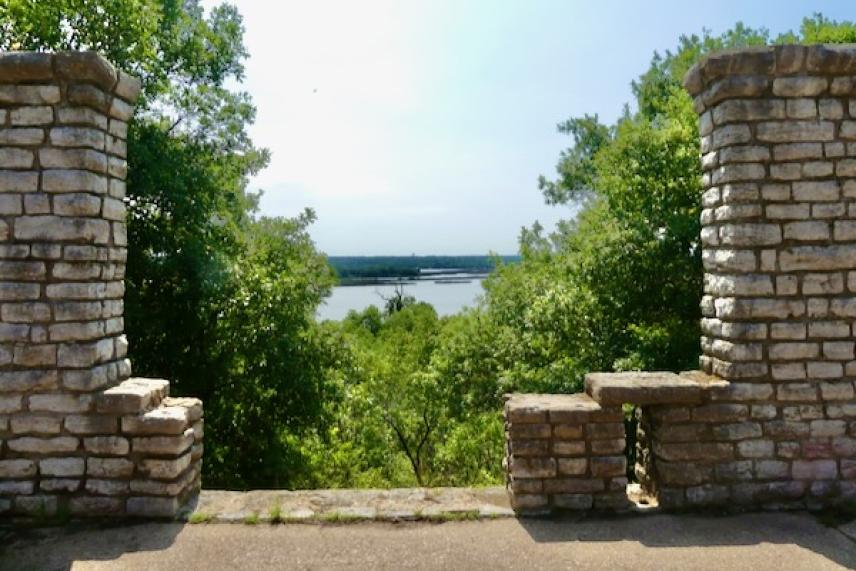 Stone overlook with trees and a river view.