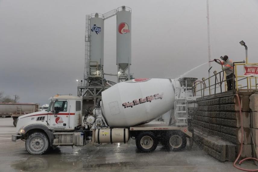 Concrete mixer truck being washed at a construction site.