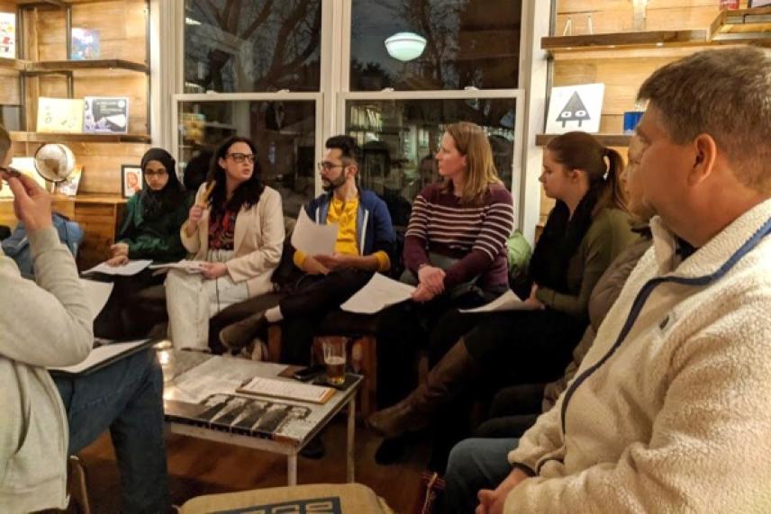 Group of people having a meeting in a cozy room with books and papers.