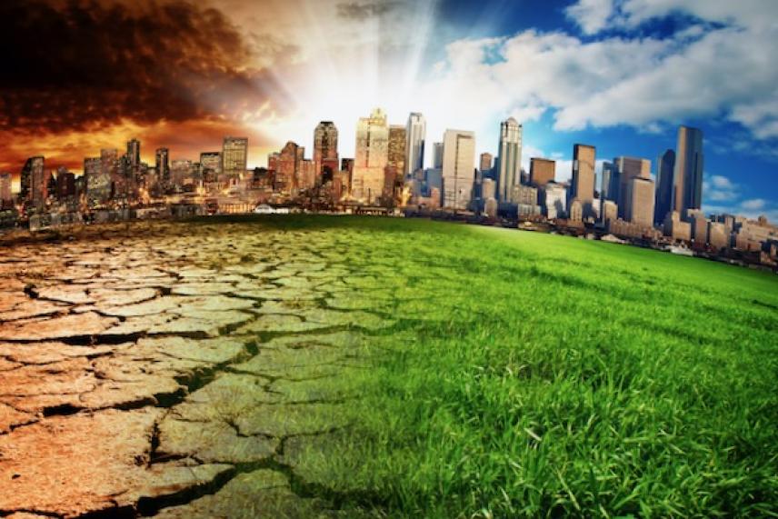 Split cityscape: barren land under smoky sky on left, lush grass under clear sky on right.