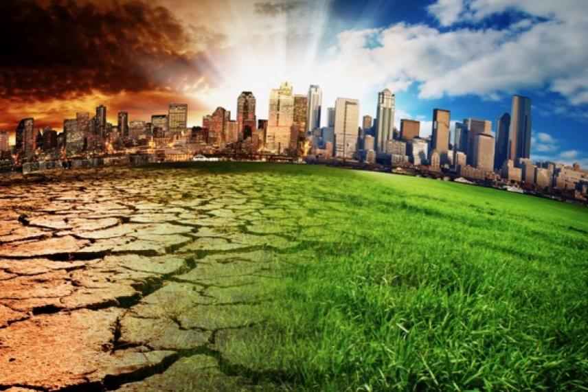 City skyline split by dry, cracked earth and vibrant green grass under contrasting skies.