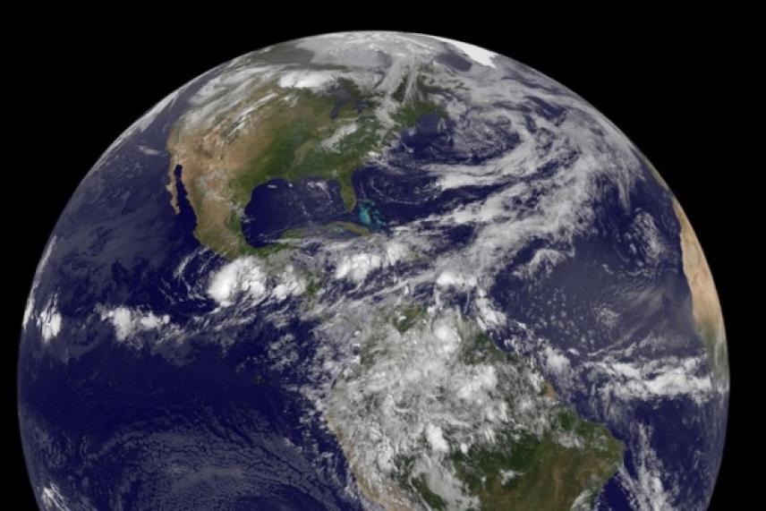Earth from space showing North and South America, with clouds and oceans visible.