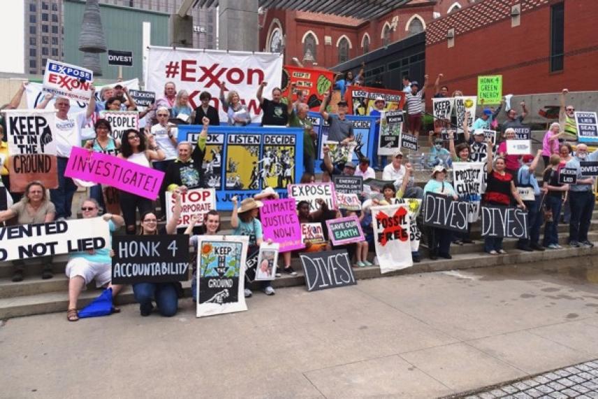 Protesters holding signs outside buildings on a city street.