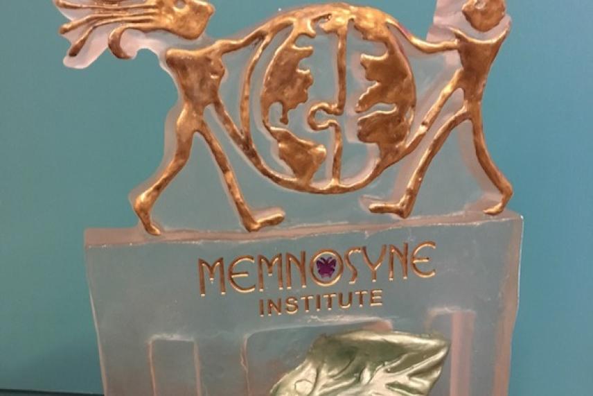 Bronze award with figures holding a globe, "Memnosyne Institute" text.