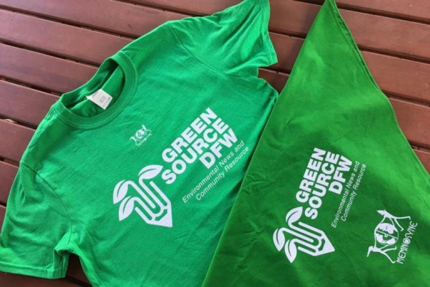 Green T-shirt and bandana with white text and leaf graphics on a wooden surface.