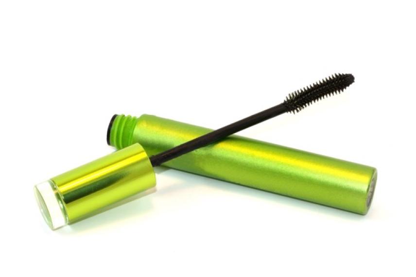 Open green mascara tube with applicator wand.