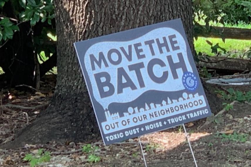 Sign on lawn saying "MOVE THE BATCH" near a tree, with additional text below.