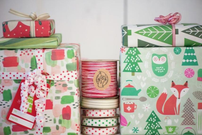 Colorful wrapped gifts with festive patterns and ribbon spools.