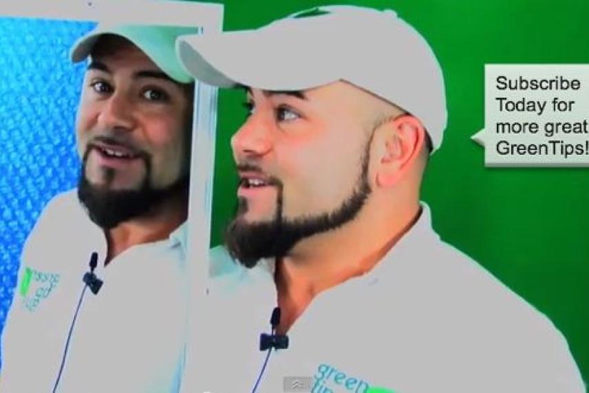 Man in white cap and polo shirt smiling, with reflection in a mirror.