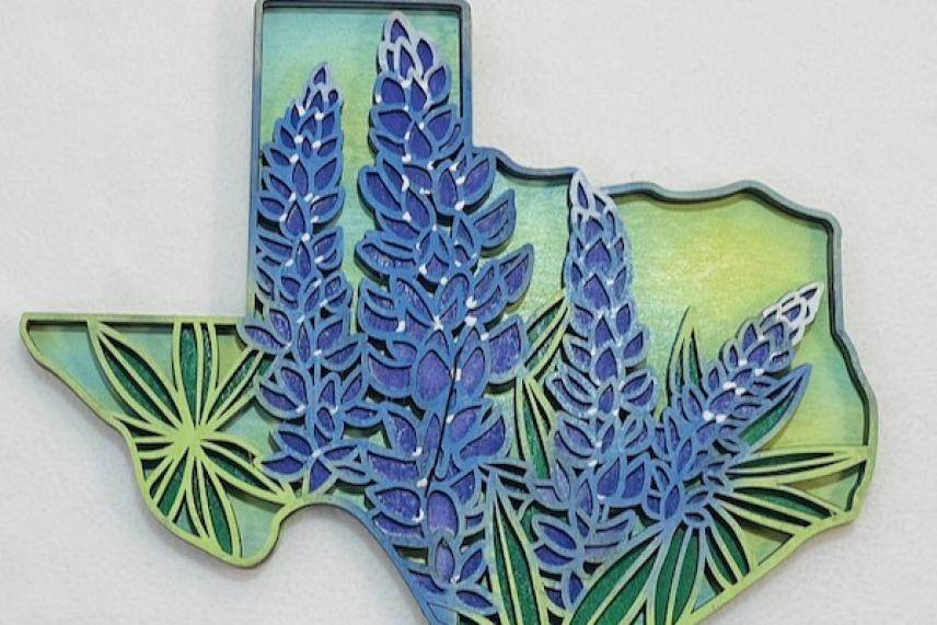Texas shape with bluebonnets and green leaves on a light background.