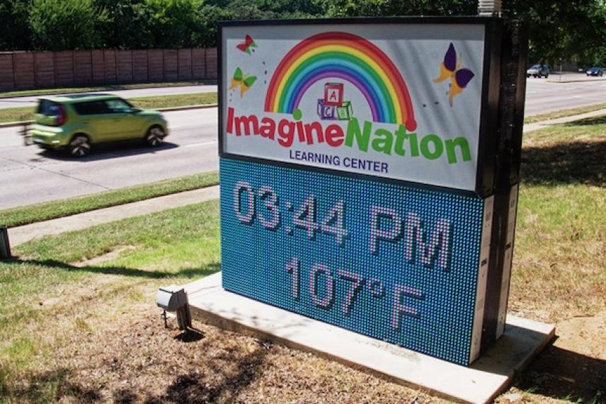 Outdoor sign displays 3:44 PM, 107°F, with vibrant rainbow and butterflies.