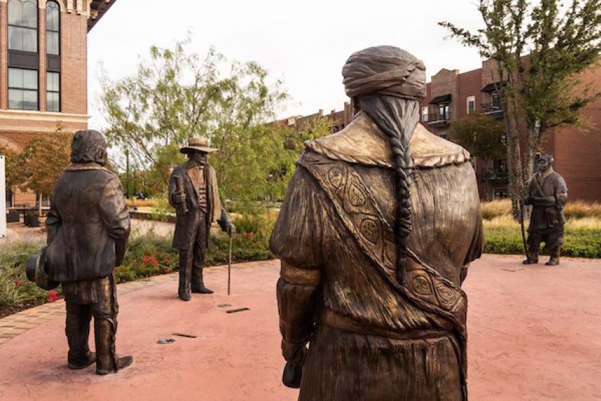 Bronze statues of historical figures in a courtyard setting.