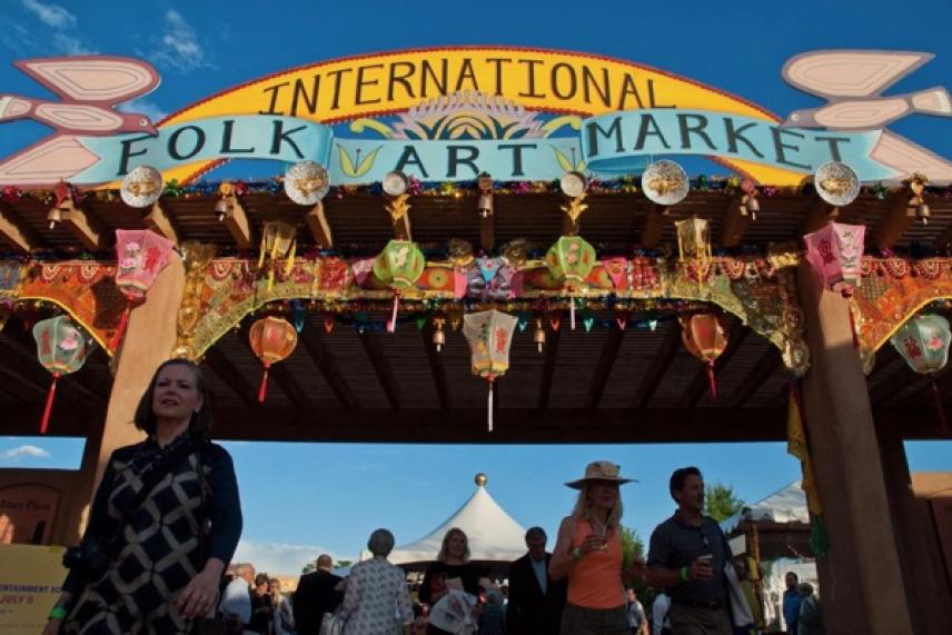 International Folk Art Market entrance with colorful decorations and a lively crowd.