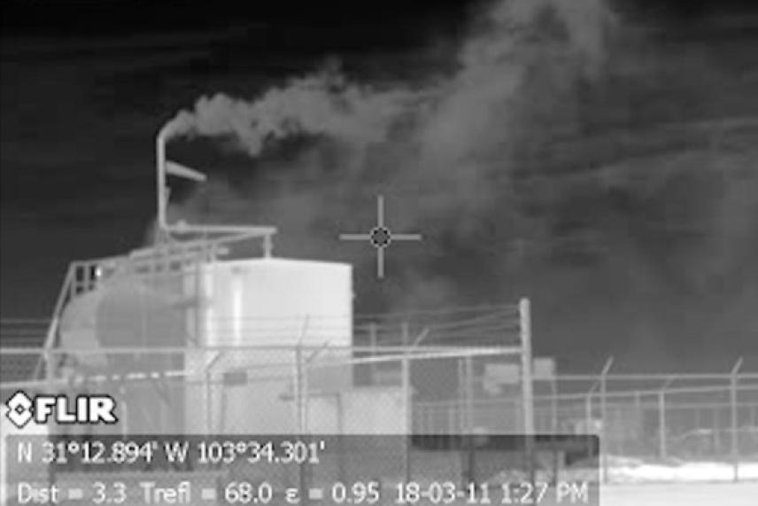 Infrared photo of industrial tanks emitting smoke.