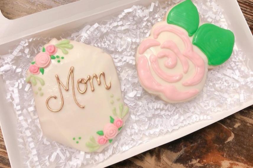Cookies shaped like "Mom" and a pink rose with green leaves.