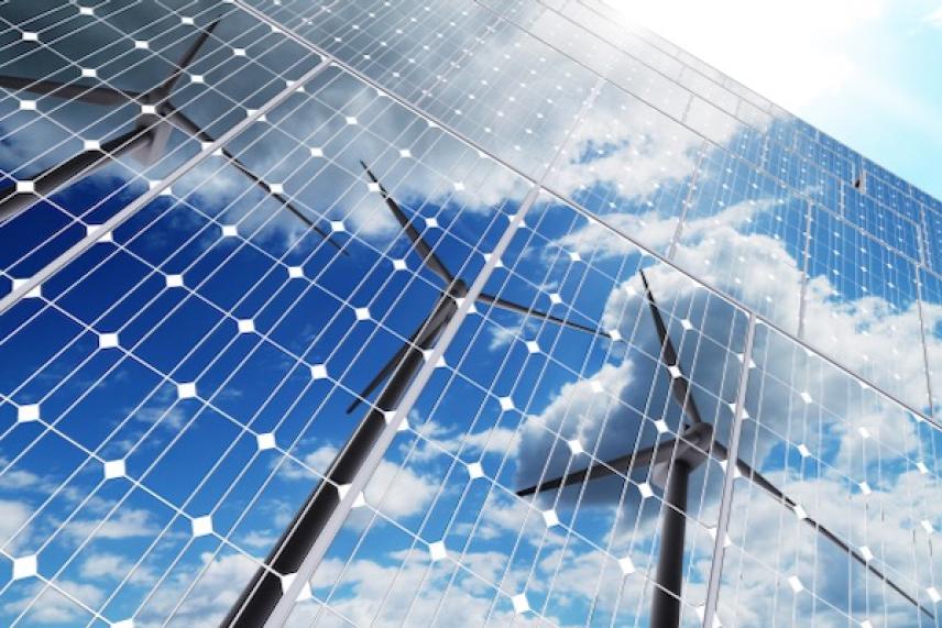 Solar panels reflecting wind turbines and clouds.