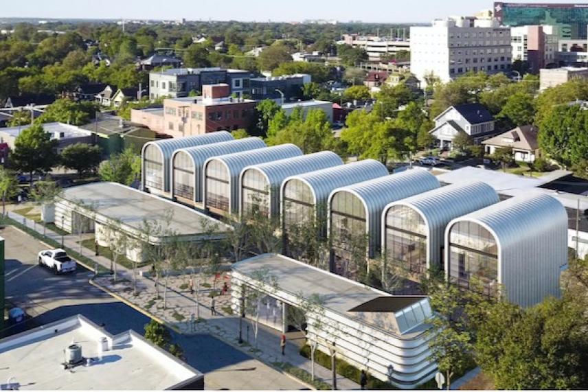 Modern urban architecture with curved metal roofs, surrounded by trees and cityscape.