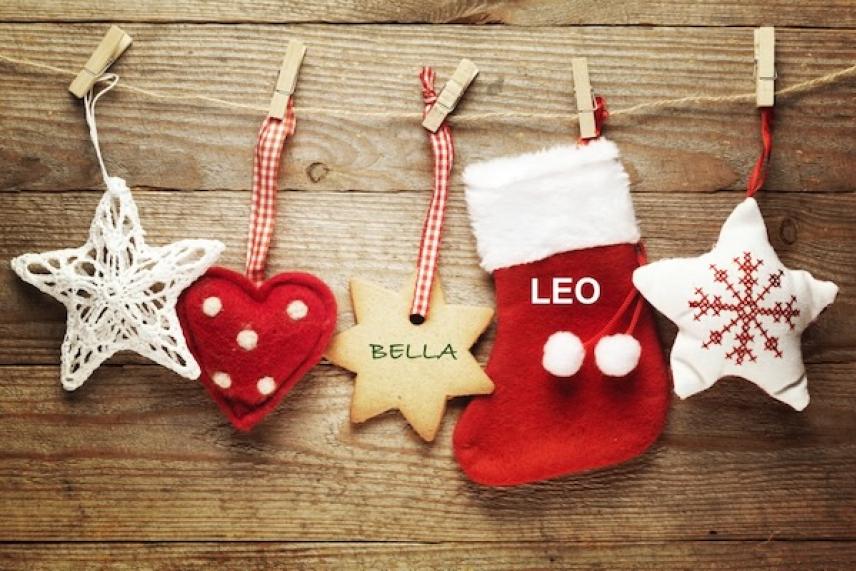 Star, heart, star, stocking, and snowflake hang on a wooden background.