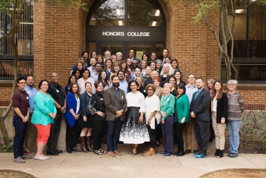 Group photo of people standing outside a building labeled "Honors College."