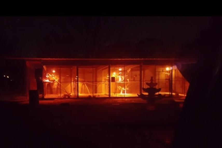 A dark building interior lit by warm, orange lights at night.