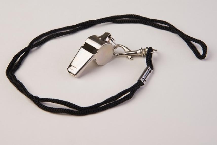 Silver whistle with black cord on a white background.