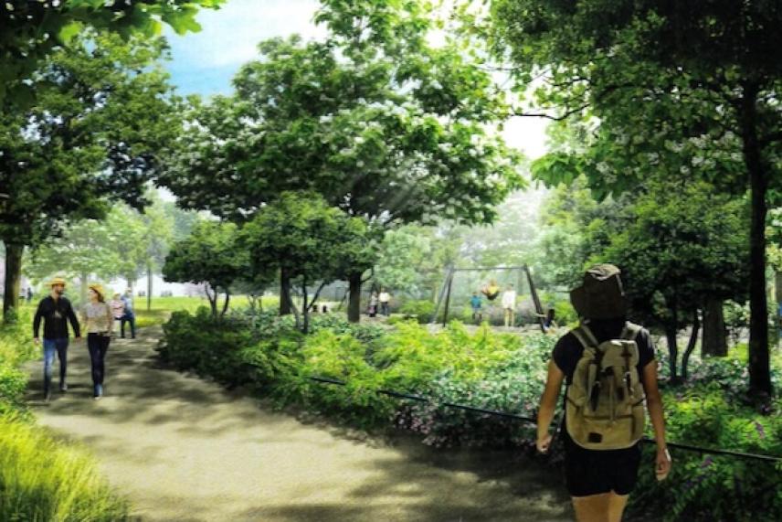 Pathway in a park with people walking under green trees.