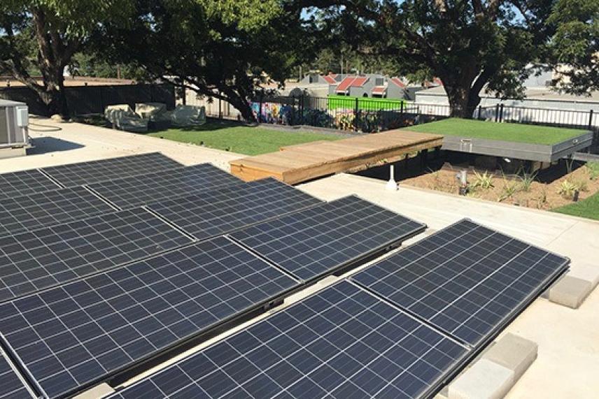 Solar panels on a patio, trees in the background.