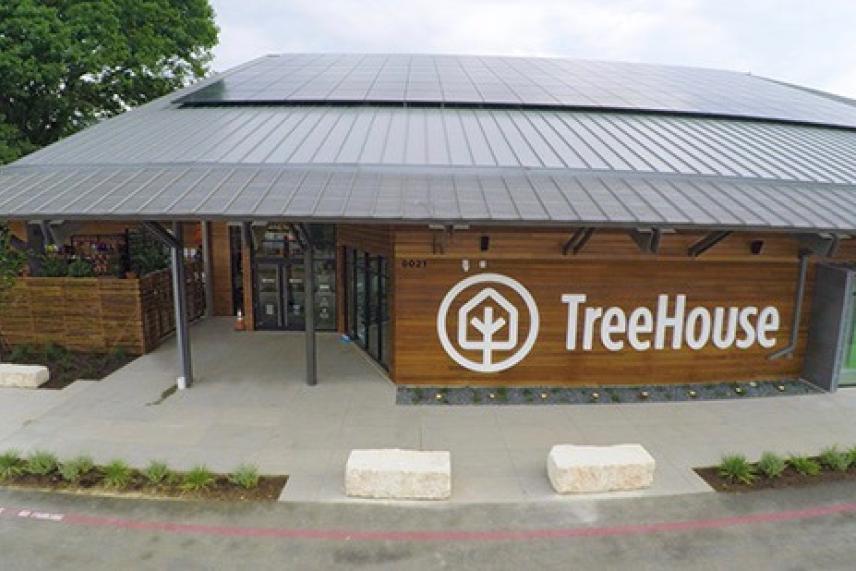 Eco-friendly store with solar panels, TreeHouse logo on wooden facade.