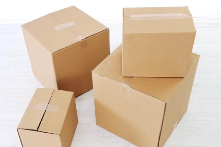 Four cardboard boxes stacked in a bright room.