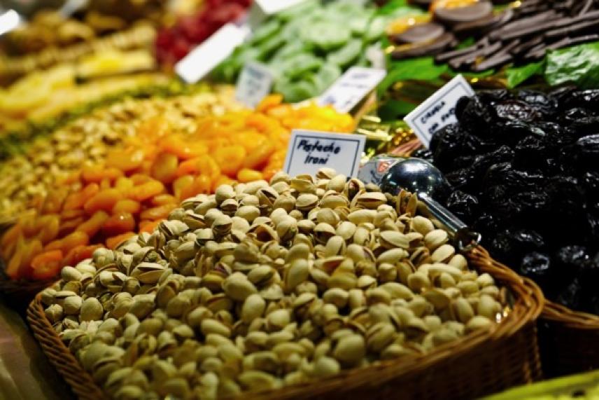 Assorted dried fruits and nuts in baskets at a market.