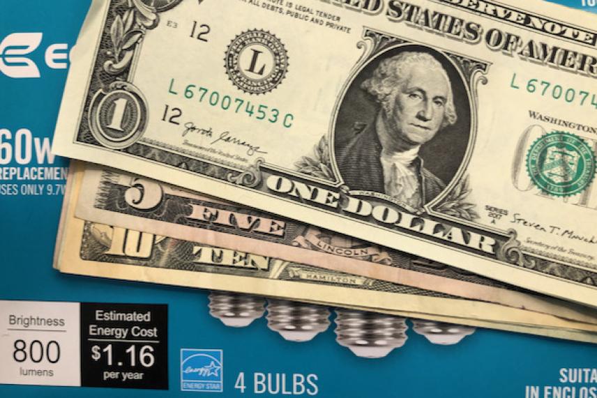 U.S. dollar bills on a package of light bulbs.
