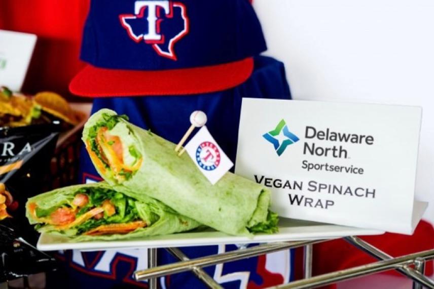 Vegan spinach wraps on a tray with sports merch in the background.