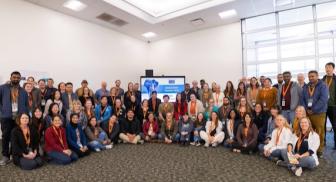 Group of people in a conference room, smiling at the camera.