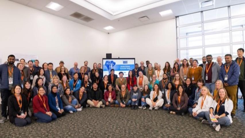 Group of people in a conference room, smiling at the camera.